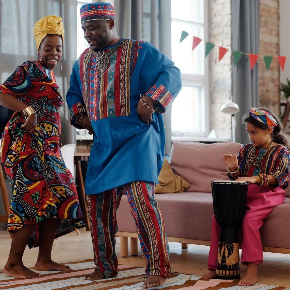 Family showing their cultural dance as a child plays the drums and watch